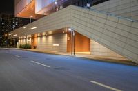 a corner with light posts near the entrance to a building and a ramp in the distance