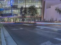 a red fire hydrant is on the street outside of an office building at night