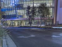 a red fire hydrant is on the street outside of an office building at night