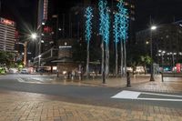 some lights on some concrete poles and buildings in the city at night time and water