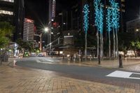 some lights on some concrete poles and buildings in the city at night time and water