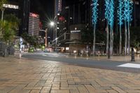 some lights on some concrete poles and buildings in the city at night time and water