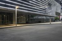 an empty parking lot with a large lighted sign next to a glass door on the side of the road