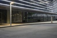 an empty parking lot with a large lighted sign next to a glass door on the side of the road