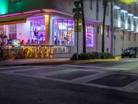 a restaurant with neon lights on at night by the beach side road in miami, florida