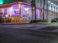 a restaurant with neon lights on at night by the beach side road in miami, florida