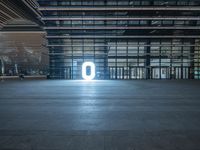 a large empty room is lit up with neon lights, inside a skyscraper building there are various windows