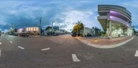 this street has parked cars on both sides of it as if fisheyes are reflected in the glass