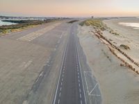 an overhead view of an empty runway with no people on it in the distance and an airport runway in the middle