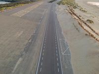 an overhead view of an empty runway with no people on it in the distance and an airport runway in the middle