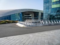 the curved concrete structure with several small statues outside of it stands out from behind the modern glass wall