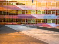 the side of a large building with a flag in front of it at sunset time