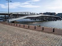 this photo shows the walkway across the canal on the side of the river as well as the footbridge