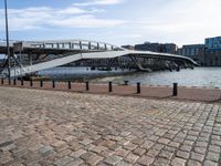 this photo shows the walkway across the canal on the side of the river as well as the footbridge