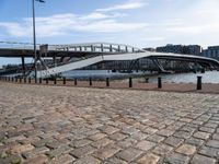 this photo shows the walkway across the canal on the side of the river as well as the footbridge