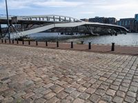 this photo shows the walkway across the canal on the side of the river as well as the footbridge