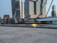 there is a bicycle with the back rack attached near a body of water and skyscrapers in the background