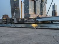 there is a bicycle with the back rack attached near a body of water and skyscrapers in the background