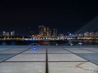 a couple of benches that are sitting in front of a body of water on a city sidewalk