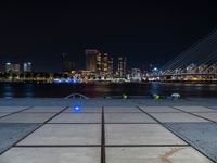 a couple of benches that are sitting in front of a body of water on a city sidewalk