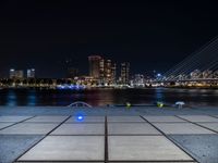 a couple of benches that are sitting in front of a body of water on a city sidewalk