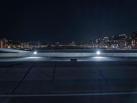 a night scene of cars on the road outside at a building top in a city