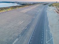 an aerial view of a roadway on a beach side highway that is paved with white lines