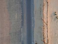 two airplanes on an empty runway from above in the desert, with a line of white lines