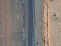 two airplanes on an empty runway from above in the desert, with a line of white lines