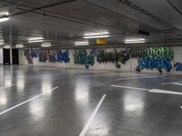 several cars parked in an underground parking lot with graffiti on the walls and ceiling and floor