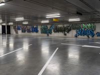 several cars parked in an underground parking lot with graffiti on the walls and ceiling and floor