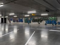 several cars parked in an underground parking lot with graffiti on the walls and ceiling and floor