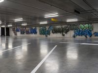 several cars parked in an underground parking lot with graffiti on the walls and ceiling and floor