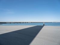 a long concrete walkway with a parking spot and pier in the background, as if on a boat