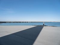 a long concrete walkway with a parking spot and pier in the background, as if on a boat