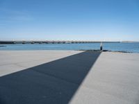 a long concrete walkway with a parking spot and pier in the background, as if on a boat