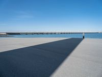 a long concrete walkway with a parking spot and pier in the background, as if on a boat