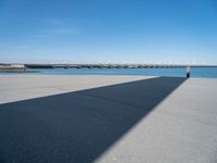 a long concrete walkway with a parking spot and pier in the background, as if on a boat