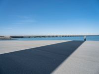 a long concrete walkway with a parking spot and pier in the background, as if on a boat