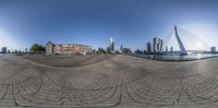 a fish - eye view of the city is reflected in this circular image of the building and bridge