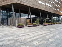 a photo of a building made of wooden and concrete with different planters on the side