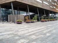 a photo of a building made of wooden and concrete with different planters on the side