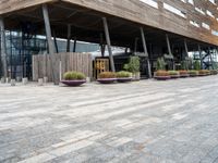 a photo of a building made of wooden and concrete with different planters on the side