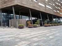 a photo of a building made of wooden and concrete with different planters on the side