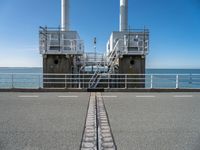 the sea side of a pier with a metal staircase going to it next to the water