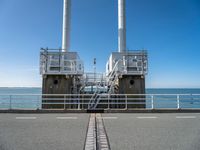 the sea side of a pier with a metal staircase going to it next to the water