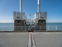 the sea side of a pier with a metal staircase going to it next to the water