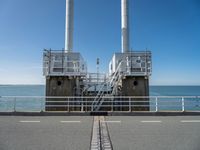 the sea side of a pier with a metal staircase going to it next to the water