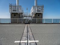 the sea side of a pier with a metal staircase going to it next to the water