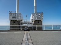 the sea side of a pier with a metal staircase going to it next to the water